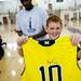 A dexter Shooting Academy camper holds up an autographed jersey on Tuesday, July 9. Daniel Brenner I AnnArbor.com